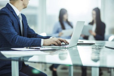 modern bir ofiste işyerinde finansal veriler ile dizüstü bilgisayar üzerinde çalışan mali yöneticisini