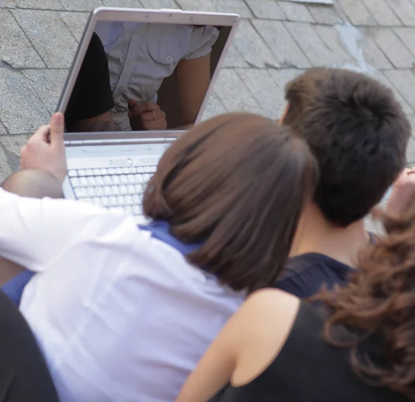 Visão traseira. o grupo de amigos de estudantes com um computador portátil — Fotografia de Stock