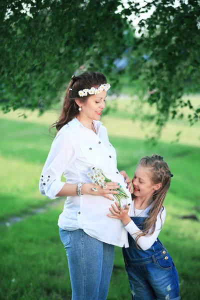 Concept of education - a pregnant mother and her little daughter — Stock Photo, Image