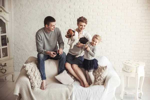 Retrato de família feliz com cão de estimação no sofá na sala de estar — Fotografia de Stock