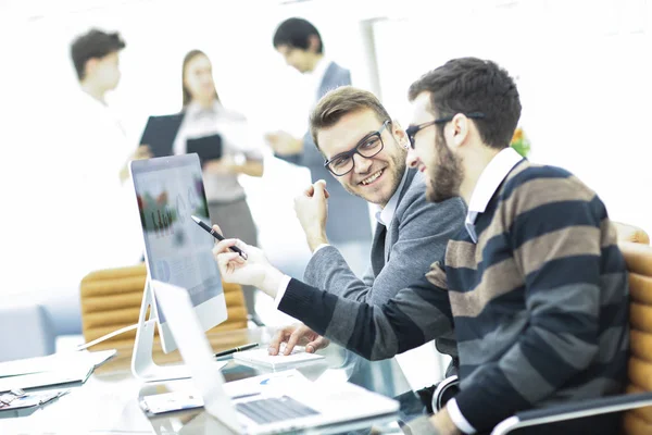 Бизнес-команда обсуждает маркетинговые схемы на рабочем месте на фоне сотрудников компании — стоковое фото