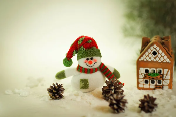 Speelgoed sneeuwpop en een peperkoek huis op een lichte achtergrond. — Stockfoto