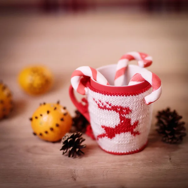 Tazza di Natale e arance su sfondo di legno sfocato. — Foto Stock