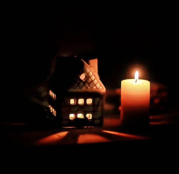 Perník dům svíčka na rozmazaném pozadí stolu. — Stock fotografie