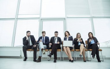 iş takım smartphone ve modern ofis lobisinde otururken dizüstü bilgisayar ile