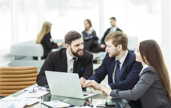 Exitoso equipo de negocios trabajando en el ordenador portátil y haciendo el informe financiero actual — Foto de Stock