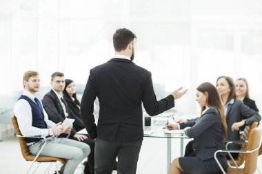 şirketin üst düzey yöneticisi iş ekibi ile bir Danışma toplantısı modern ofisinde tutuyor.