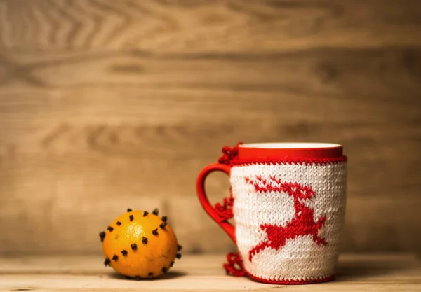 Taza de tela de lana aislada con ciervos bordados en la mesa de madera con mandarina — Foto de Stock