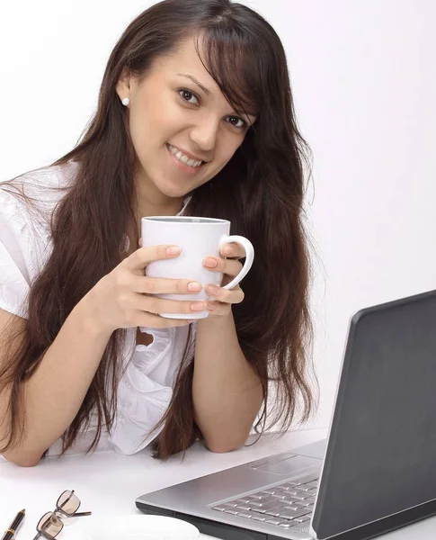 Mujer joven con taza de té sentado en el lugar de trabajo — Foto de Stock