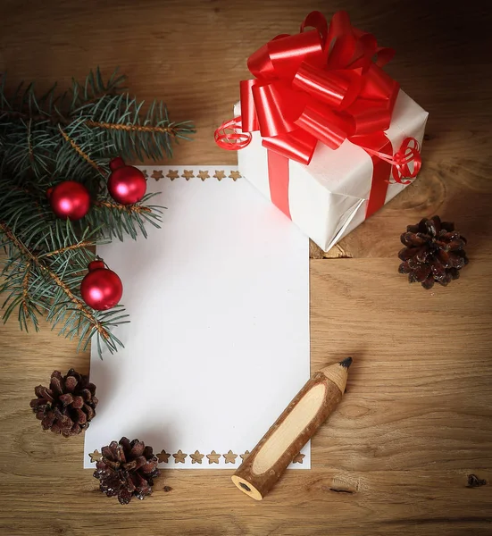 Пустая рождественская открытка и коробка с подарком на рождественском фоне — стоковое фото