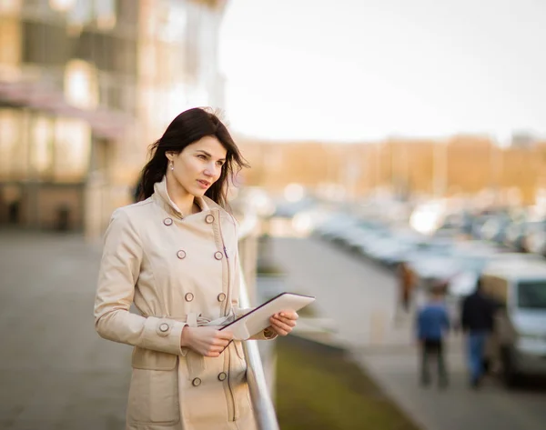 Moderne zakenvrouw werken op een digitale tablet, staande naast een kantoorgebouw — Stockfoto