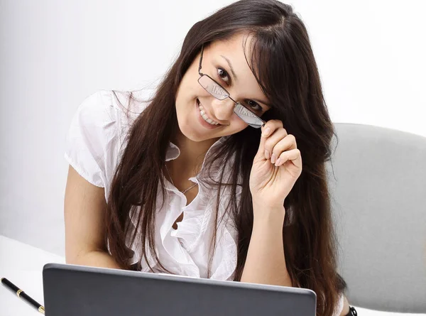 Closeup.sorrindo mulher de negócios sentada em uma mesa . — Fotografia de Stock