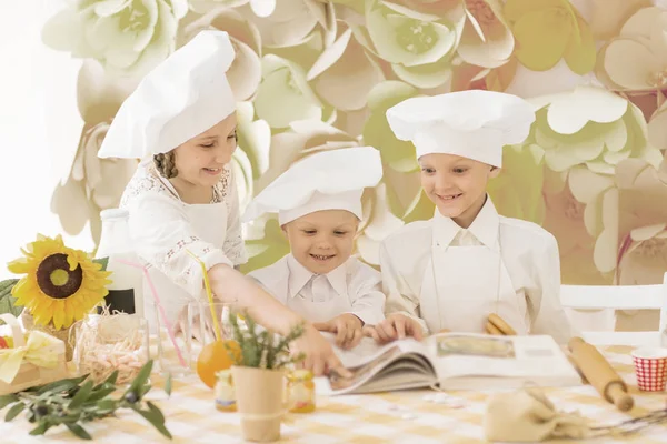 Lezzetli bir yemek hazırlamak için aşçı şeklinde mutlu küçük çocuklar. — Stok fotoğraf