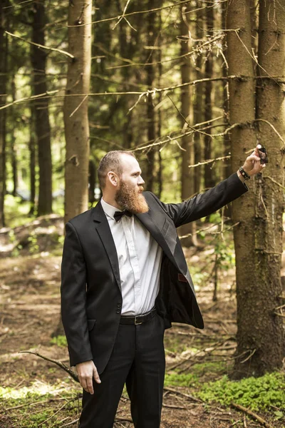 Zakenman maakt selfie op de achtergrond van dennenbos. — Stockfoto