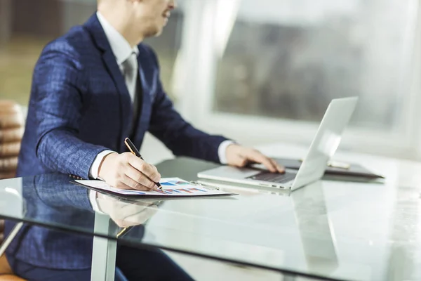 Empresário de sucesso trabalhando no laptop com dados financeiros no local de trabalho em um escritório moderno. — Fotografia de Stock