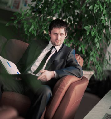 Pencerenin önünde masada oturan rahat iş adamı