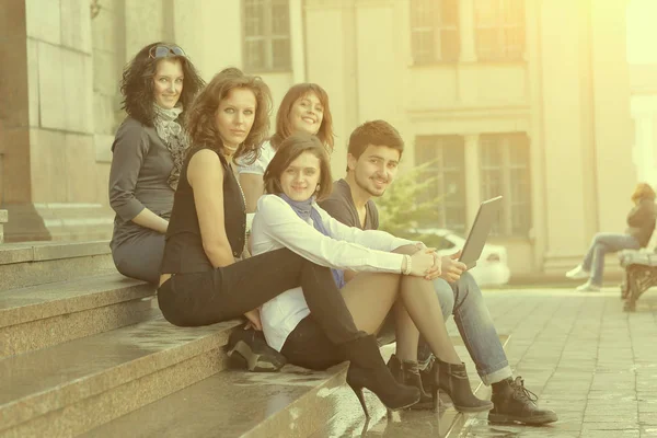 Porträtt av en grupp studenter som sitter framför universitetet — Stockfoto