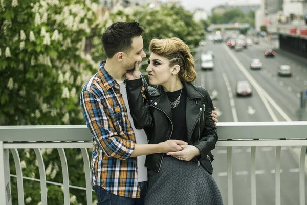 Portrait of loving couple standing on bridge in big city — Stock Photo, Image