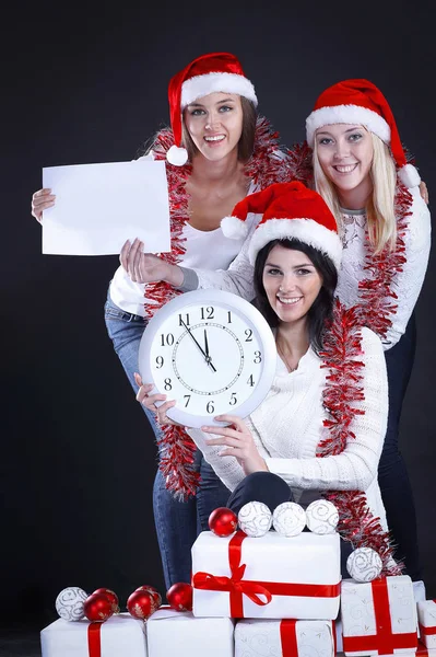 Três mulheres felizes em traje de Papai Noel com relógio, e Chris — Fotografia de Stock