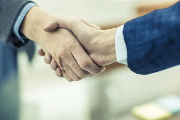 Begreppet ett pålitligt partnerskap: ett handslag av affärspartners på suddig bakgrund — Stockfoto