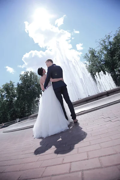 Visão traseira. feliz recém-casados de pé na praça da cidade — Fotografia de Stock