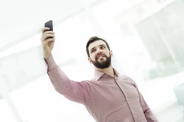 Empresário faz selfie enquanto está perto da janela no escritório — Fotografia de Stock