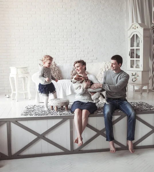 Retrato de uma família feliz e seu animal de estimação em uma sala de estar aconchegante — Fotografia de Stock