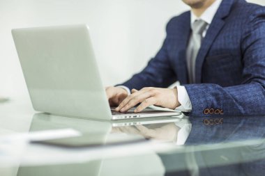 İşyerinde dizüstü bilgisayarda çalışan başarılı bir iş adamı.