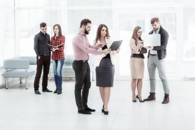 Toplantıdan önce Office lobide duran belgeleri tartışırken iş takım