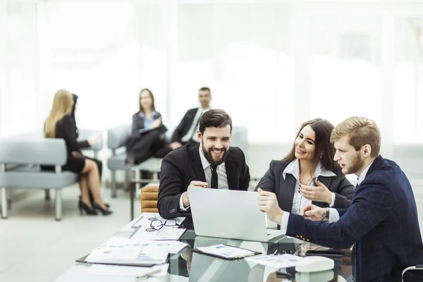 Empleados de la empresa trabajan en el ordenador portátil con información sobre el desarrollo de la empresa — Foto de Stock