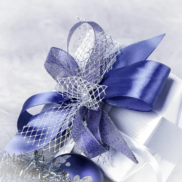 Δώρο Χριστουγέννων και μπλε Χριστούγεννα μπάλες σε ένα γιορτινό λευκό πίσω — Φωτογραφία Αρχείου