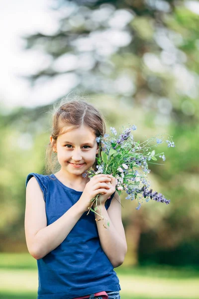 Petite fille avec un bouquet de fleurs sauvages — Photo