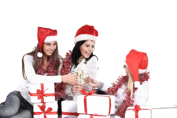 Três mulheres jovens em chapéus de Papai Noel com presentes de Natal um — Fotografia de Stock