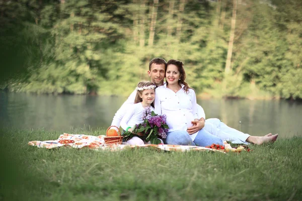 Šťastná rodina: otec, těhotné matky a malou dceru na pi — Stock fotografie