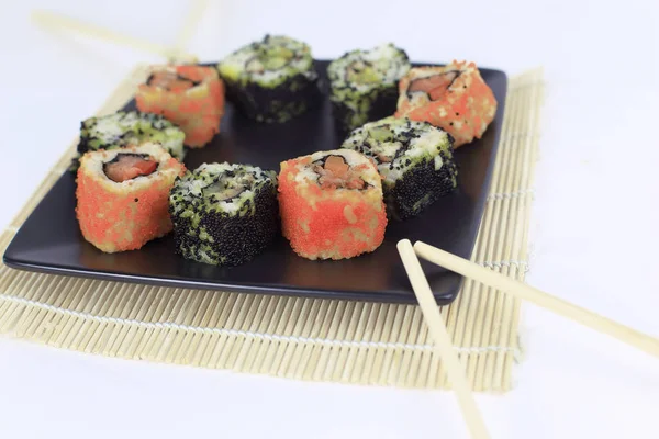 Sushi seti - Maki sushi ve çubuk siyah bir plaka üzerinde farklı — Stok fotoğraf