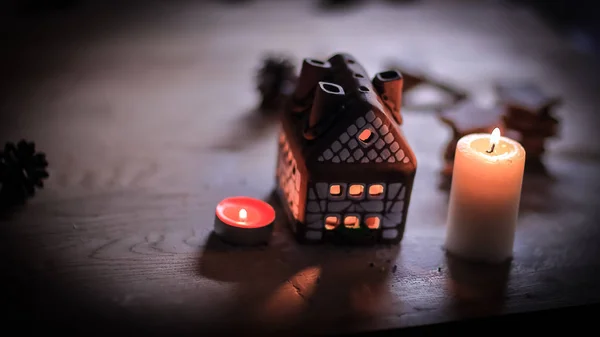 Пряничный домик свеча на размытом фоне стола. — стоковое фото