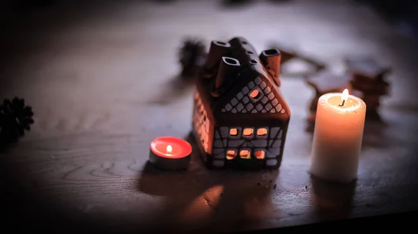 Gingerbread house candle on blurred background of the table. — Stock Photo, Image