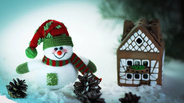 Іграшковий сніговик і пряниковий будинок на світлому фоні . — стокове фото