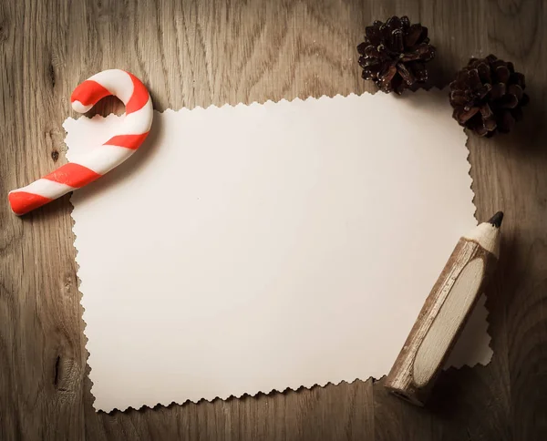 Cartão de saudação em branco para o Natal e lápis em backgroun de madeira — Fotografia de Stock