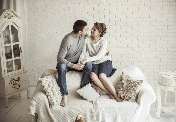 Portrait d'un jeune couple amoureux assis sur un canapé dans le salon — Photo