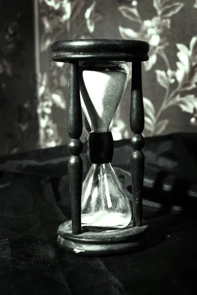 Closeup.hourglass with white sand on a wooden table — Stock Photo, Image