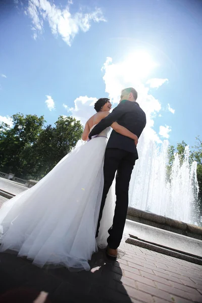 Vista trasera. novios felices en el fondo de la plaza de la ciudad —  Fotos de Stock