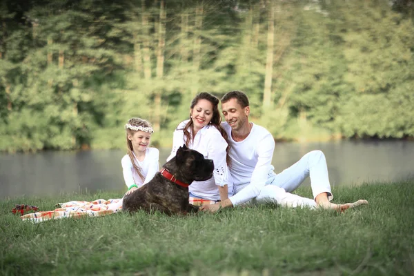 Gelukkige familie met huisdier hond bij de picknick in een zonnige zomerdag. pregn — Stockfoto