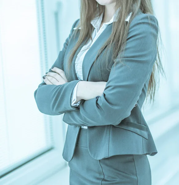 Framgångsrik affärskvinna som står nära fönster med händerna claspe — Stockfoto