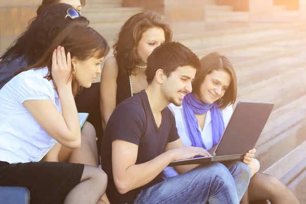Vrienden van de studenten kijken naar de laptop scherm — Stockfoto