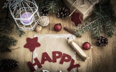 tebrik kartı, kalem, mum ve Noel dekorasyonu ahşap arka plan üzerinde