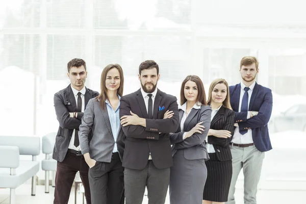 Porträtt av en sammansvetsad business team står bredvid varandra i lobbyn på kontoret — Stockfoto