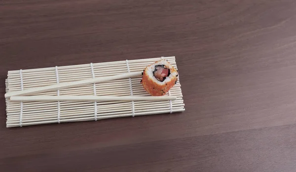 Sushi i pałeczki na podłoże drewniane. — Zdjęcie stockowe