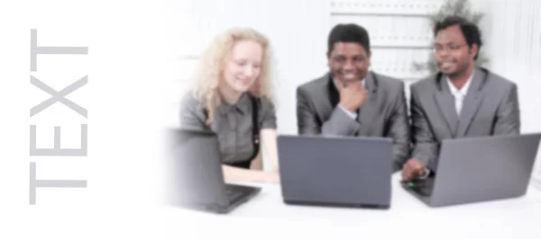 Imagen borrosa, los empleados miran el monitor del ordenador portátil, sentado en la mesa —  Fotos de Stock