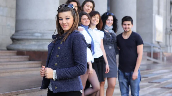 Student van het meisje op de achtergrond van het team van vrienden — Stockfoto